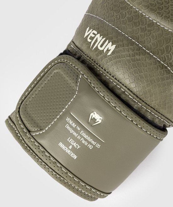 Close-up van de polsband van een legergroene bokshandschoen met 'Venum' logo en tekst.