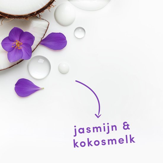 Gebroken kokosnoot met paarse jasmijnbloemen, blaadjes en druppels.