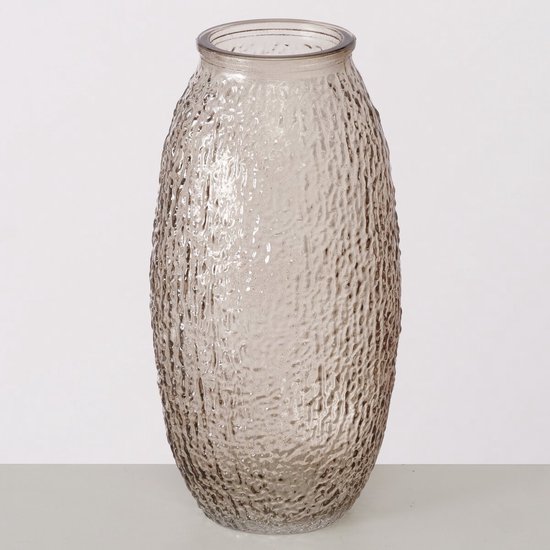 Ovale glazen vaas in bruin-beige tinten met een ruw, bobbelig oppervlak, staand op een witte ondergrond.
