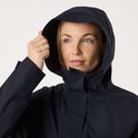 Gros plan sur la capuche d'un manteau noir, une main tenant la capuche.