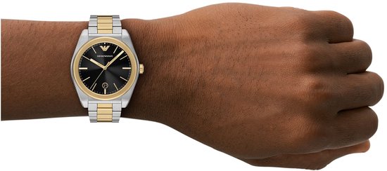 Bicolor horloge met goudkleurige accenten gedragen om een donkere pols.