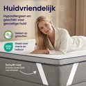 Femme sur un matelas, avec label Oeko-Tex. Dessous antidérapant avec des sangles élastiques.