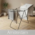 Porte-linge noir pliable avec une serviette grise et beige clair, une couverture blanche et le texte Amsterdam.