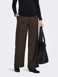 Zwangere vrouw in zwarte top en bruine wijde broek met plooien, draagt zwarte tas.