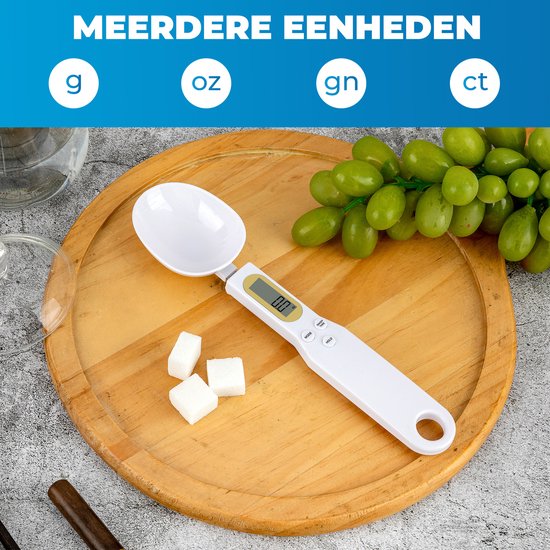 Witte lepelweegschaal met digitaal display op een houten plank. Naast de weegschaal liggen suikerklontjes en een tros druiven. Eenheden: g, oz, gn, ct.