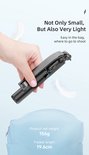 Hand houdt een compacte, zwarte selfie-stick vast die opgevouwen is tot een klein formaat.