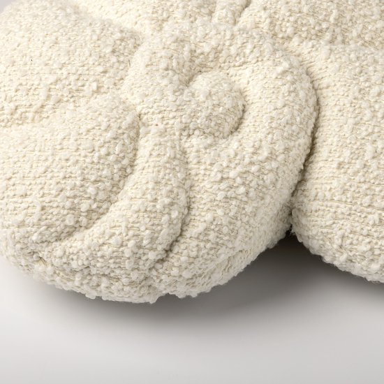Sierkussen in schelpvorm van witte bouclé stof. Gedetailleerde krullen en textuur.