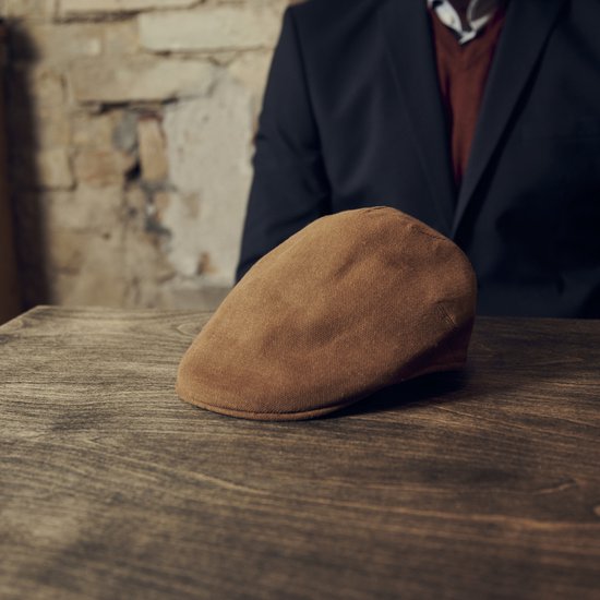 Bruine moda platte pet op een houten tafel.