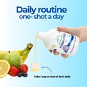 Vloeistof uit fles Encapsulated PROBIOTICS wordt in een maatbekertje gegoten, met fruit op de achtergrond.