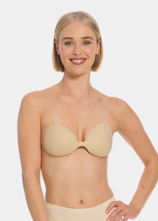 Model met blote schouders draagt een beige, plakbeha met voorsluiting. Ze glimlacht en leunt met één hand op haar heup.