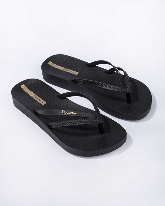 Zwarte Ipanema platform slippers, schuin van voren gezien, met gevlochten bandjes en gouden logo.