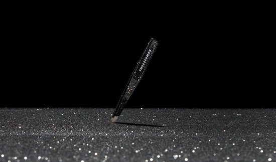 Tweezerman schuine pincet met zwarte glitter, op een achtergrond van glitters.