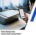 Man houdt smartphone met printer app voor een zwarte HP DeskJet printer.