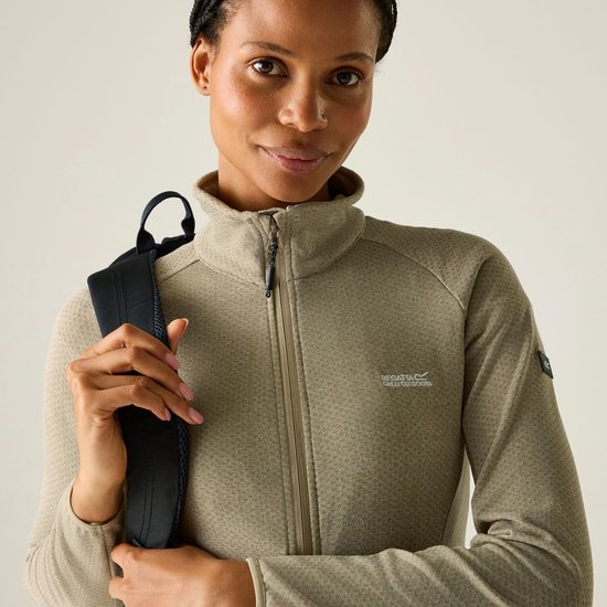 Close-up van model die beige fleece jas met rits draagt.