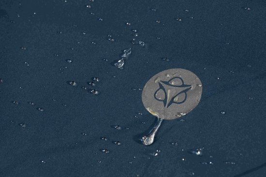 Donkerblauwe stof met waterdruppels en een rond logo.