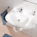 Moderne wastafel met glanzende chroom kraan, handdoek en accessiores.