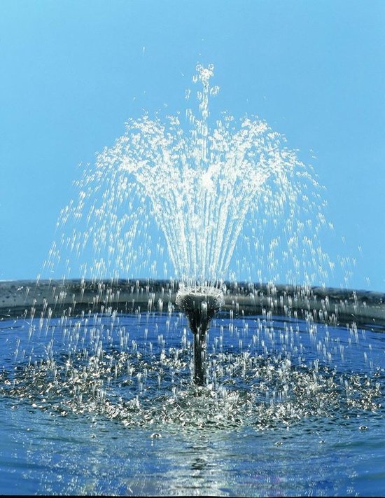 Pompe de fontaine avec un jet d'eau large et jaillissant sur un ciel bleu.