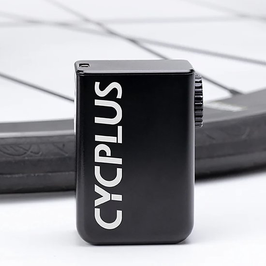 Zwarte CYCPLUS Tiny Cube fietspomp met witte tekst, naast een fietsband.