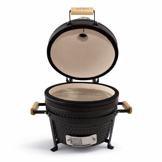 Openstaande zwarte Patton Kamado barbecue met grillrooster en witte binnenkant.