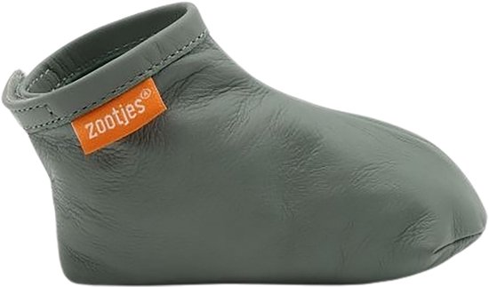 Mosgroene babyslof van leer met oranje 'zootjes' label, van de zijkant.