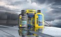 Twee flessen Rain-X producten en een value pack op het glimmende, natte oppervlak van een auto. Op de achtergrond een dramatische lucht.