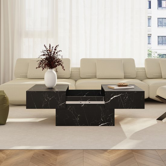 Zwarte salontafel met marmerlook in een woonkamer, naast een beige bank.