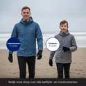 Man en jongen op het strand, beide met winterjassen en zwarte handschoenen.