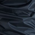 Detail van de donkerblauwe, waterdichte stof van een jas.