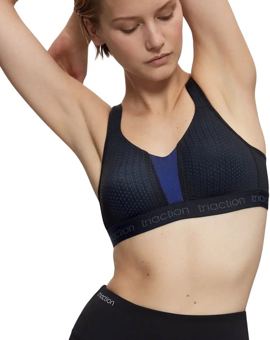 Zwarte sportbeha met een blauw detail en gestippelde print, gedragen door een model.