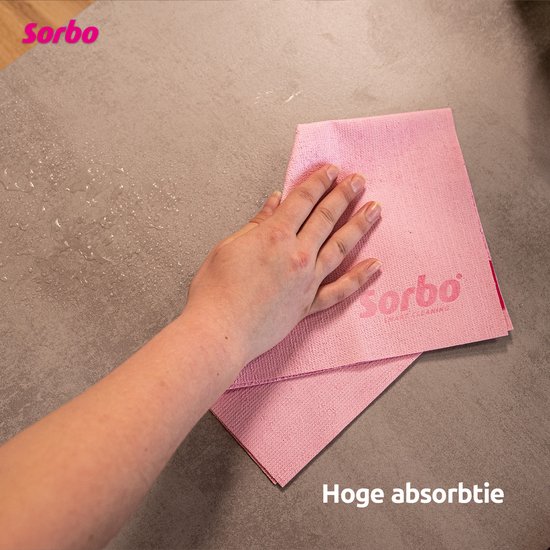 Hand die een roze Sorbo microvezeldoek gebruikt op een nat aanrecht.