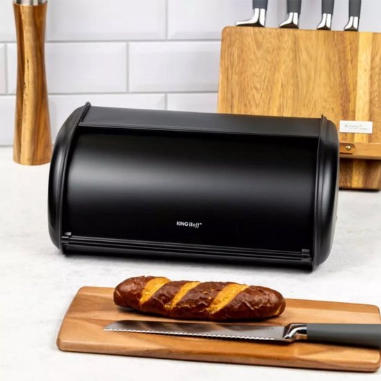 Boîte à pain noire avec une baguette à côté sur une planche en bois avec un couteau.