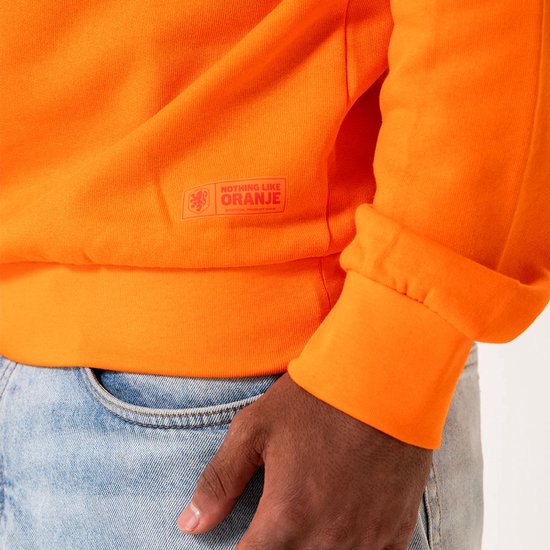 Detail van een oranje trui met tekst "NOTHING LIKE ORANJE" en "OFFICIAL PRODUCT".