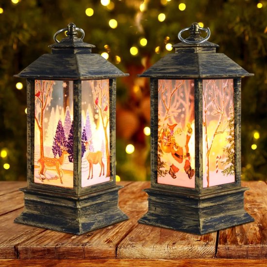 Deux petites lanternes de Noël illuminées avec des images du Père Noël et de rennes dans un paysage hivernal.