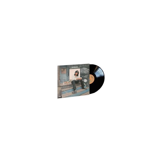 LP hoes van Rodriguez, Coming From Reality, met een zwart vinyl er naast. Een man zit op een houten trap met een gebroken witte blouse, zonnebril en donkere broek.