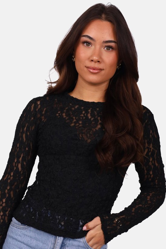 Model in zwarte kanten top met ronde hals, detail van het kant.