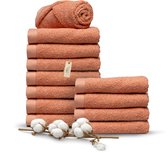 Stapel zalmroze handdoeken van Miss Towels met katoenbloemen.