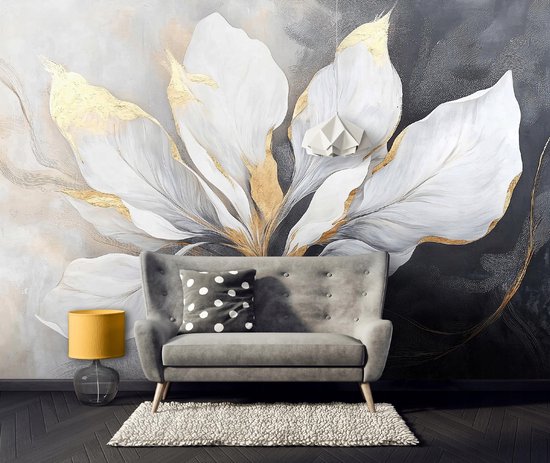 Een fauteuil voor een grijze bank met een kussen met stippen, een gele lamp en een geborduurd vloerkleed, tegen een muurschildering met witte bloembladen.