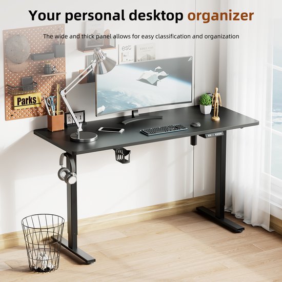 Zwart zit-sta bureau ingericht met monitor, lamp, koptelefoon, mobiel, mandje en prullenbak.