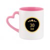 Mug blanc avec anse rose en forme de cœur et "30 JAAR" dans un ovale doré sur fond noir avec des étoiles.