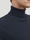 Detail van de donkerblauwe coltrui met de kraag omhoog.