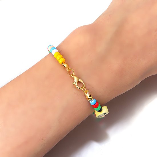 Armband gedragen om een pols, met gekleurde kraaltjes, een goudkleurige karabijnsluiting en een smileybedeltje.