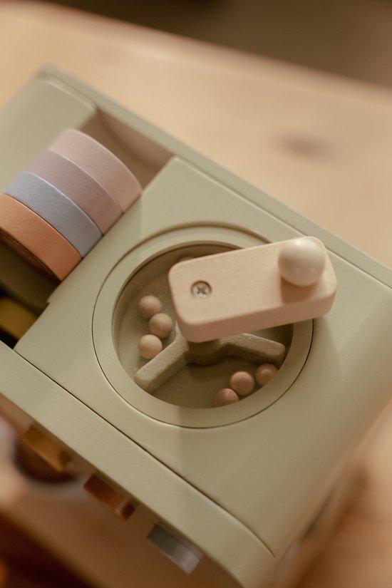 Detail van een houten speelgoed machine met pastelkleurige stapelringen en houten knoppen.