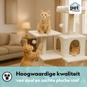 Beige kattenkrabpaal met verschillende verdiepingen. Een oranje kat zit boven en een andere speelt met een paal.