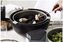 Zwarte tafelgrill met houtskool en een brandende aansteeklont.