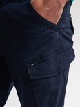 Close-up van de opgestikte cargobroekzak op een donkerblauwe broek met Petrol Industries label.