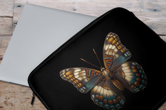 Laptop sleeve met kleurrijke vlinder print, naast een zilverkleurige laptop op een houten ondergrond.