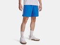 Man in een blauwe Under Armour sportbroek met 'UNDER ARMOUR' logo op de zijkant.