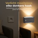 Zwarte stekkerlamp verlicht een donkere hoek, naast een stopcontact. Ideaal voor gangen of overloop zonder schakelaars.