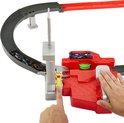 Hand bedient de lanceerder van de Hot Wheels F1 racebaan, met auto's op de baan en in de startpoort.
