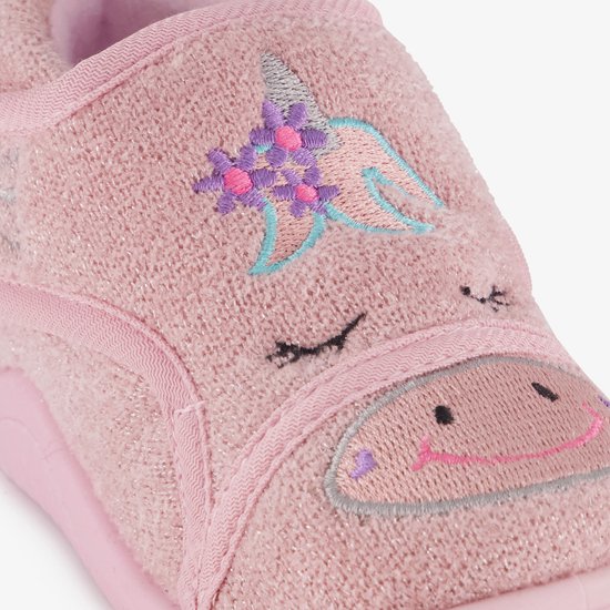 Detail van roze pantoffel met geborduurde eenhoorn.